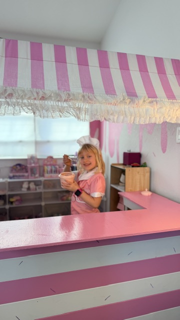 Ellie, owner of Sweet Scoops, holding an ice cream scoop